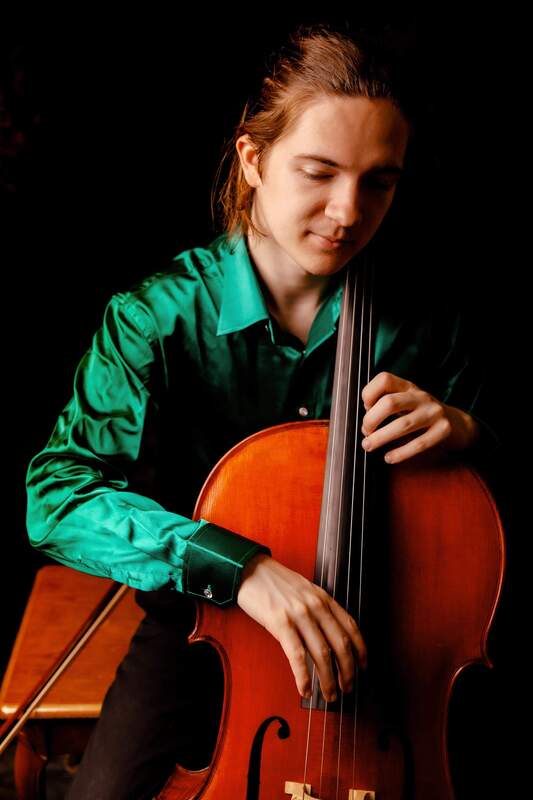 Cellist in green playing instrument