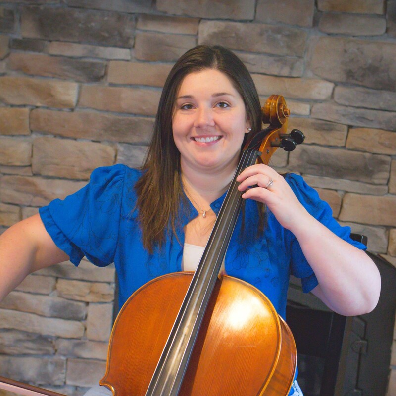 Smiling cellist posed to play instrument